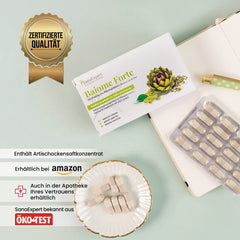 SanaExpert Baiome Forte Produktverpackung auf einem Tisch neben einer offenen Blisterpackung von Kapseln und einem Zertifikat für geprüfte Qualität, Hinweis auf Verfügbarkeit bei Amazon und in Apotheken.