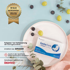 Qualitätszertifiziertes SanaExpert Gastro Forte Produkt auf einem Teller, dekoriert mit dunklen und hellen Beeren sowie Eukalyptuszweigen auf einem hellrosa Stoffuntergrund, symbolisch für Reinheit und natürliche Inhaltsstoffe.