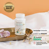 SanaExpert Haar Forte Gold präsentiert auf einem Tablett neben einer Alstroemeria Blüte, Qualitäts- und Vertrauenssiegel deutlich sichtbar.