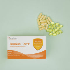 Packung von SanaExpert Immun Forte auf grünem Hintergrund mit einer Streuung von gelben und weißen Kapseln daneben, betont die Gesundheitsvorteile der Inhaltsstoffe wie Beta-Glucan und Lycopin.